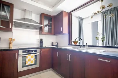 a kitchen with wooden cabinets and a sink and a window at Frank Porter - 29 Boulevard Tower 2 in Dubai