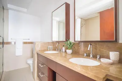 a bathroom with two sinks and a toilet and a mirror at Frank Porter - 29 Boulevard Tower 2 in Dubai
