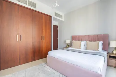 a bedroom with a large bed and wooden cabinets at Frank Porter - 29 Boulevard Tower 2 in Dubai