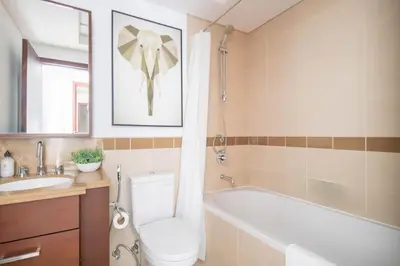 a bathroom with a toilet and a tub and a sink at Frank Porter - 29 Boulevard Tower 2 in Dubai