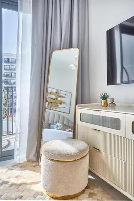 a dressing room with a mirror and a stool at Frank Porter - Azizi Beach Mirage in Dubai