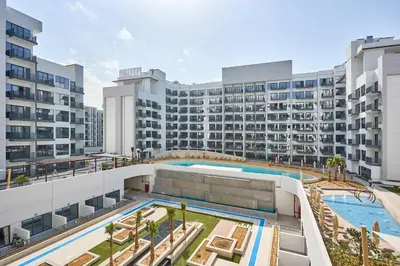 an aerial view of a building with a swimming pool at Frank Porter - Azizi Beach Mirage in Dubai