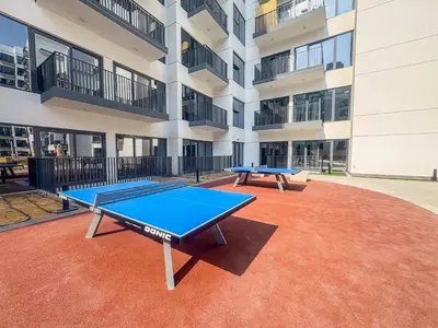 a ping pong table in front of a building at Frank Porter - Azizi Beach Mirage in Dubai