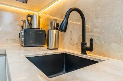 a kitchen counter with a sink and a kitchenilit at Escape24 Upgraded 1BR Al Bahar with Partial Burj & Fountain View in Dubai