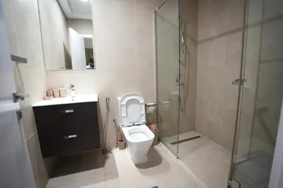 a bathroom with a toilet and a glass shower at Marina bedspace Partial Sea View close to Tram in Dubai