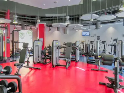 a gym with lots of cardio equipment on a red floor at FIRST CLASS 3BR Sea, Palm & Atlantis Views in Dubai