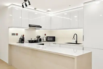 a white kitchen with white cabinets and appliances at FIRST CLASS 3BR Sea, Palm & Atlantis Views in Dubai