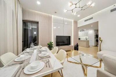 a dining room with a white table and white chairs at FIRST CLASS 3BR Sea, Palm & Atlantis Views in Dubai
