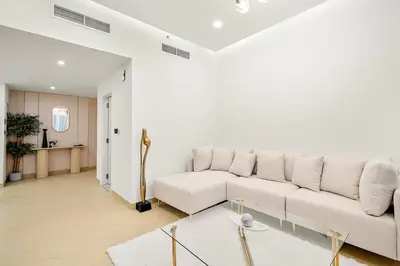 a white living room with a couch and a table at FIRST CLASS 3BR Sea, Palm & Atlantis Views in Dubai
