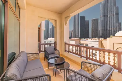 a balcony with a couch and chairs and a view of the city at Escape24 Brand New Designer 2Bedroom with fully Burj Khalifa Views in Dubai