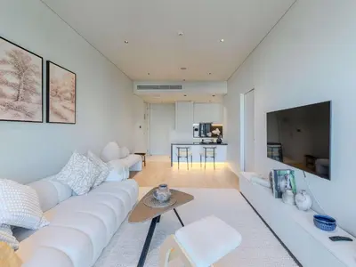 a living room with a white couch and a table at Quiet Luxury and Views at The Address Dubai Marina in Dubai