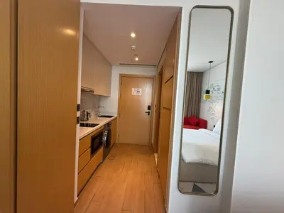 a small kitchen with a bed and a mirror at Elegant Studio Apartment with Marina View JVT in Dubai