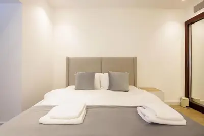 a white bed with two white towels on it at Silk Valley - Luxury 1BR | High Floor & Balcony | Sea Views in Dubai