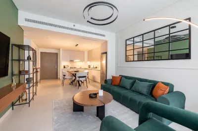 a living room with a green couch and a table at Modern 1BR in Beach Mansion with Pool and Gym in Dubai