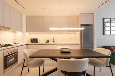 a kitchen with a wooden table and chairs at Modern 1BR in Beach Mansion with Pool and Gym in Dubai