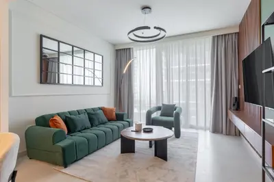 a living room with a green couch and a table at Modern 1BR in Beach Mansion with Pool and Gym in Dubai