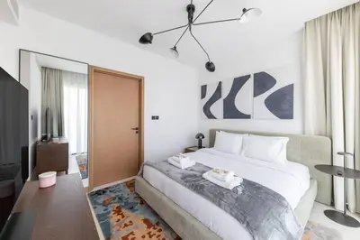a bedroom with a large bed and a tv at Vida Marina Residence High Floor Luxury 1 BR Flat in Dubai