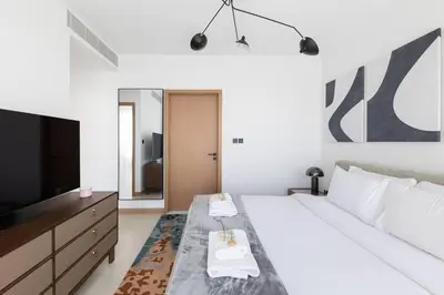 a bedroom with a large bed with a television at Vida Marina Residence High Floor Luxury 1 BR Flat in Dubai