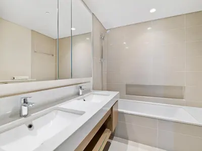 a white bathroom with two sinks and a bath tub at Enchanting 2BDR In Creek Harbour 19 in Dubai