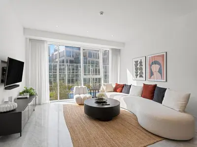 a white living room with a white couch and a table at Stylish 1-Bedroom Escape The PAD Business Bay in Dubai