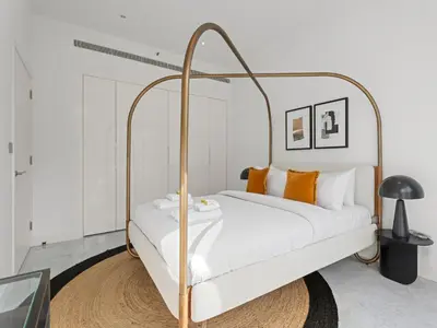 a bedroom with a white bed with a gold frame at Stylish 1-Bedroom Escape The PAD Business Bay in Dubai