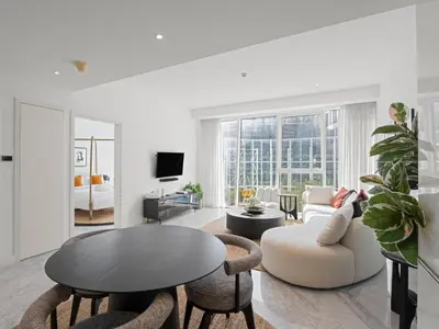 a white living room with a table and chairs at Stylish 1-Bedroom Escape The PAD Business Bay in Dubai
