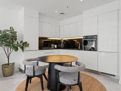 a kitchen with a wooden table and two chairs at Stylish 1-Bedroom Escape The PAD Business Bay in Dubai