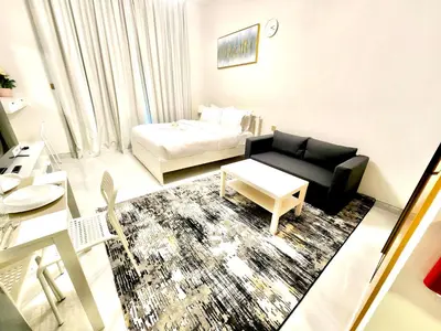 a living room with a couch and a bed at 16 Studio in Skyz By Danube, Arjan in Dubai