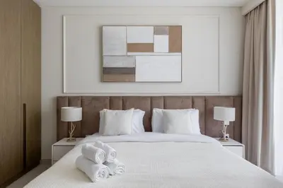 a bedroom with a white bed with towels on it at Spacious 1BR at Beach Mansion Balcony, Pool and Gym in Dubai