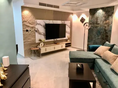 a living room with a couch and a television at Beautiful newly renovated apartment in the heart of Dubai in Dubai