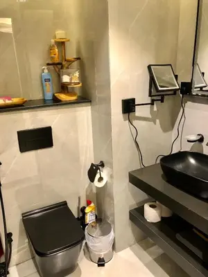 a bathroom with a black sink and a toilet at Beautiful newly renovated apartment in the heart of Dubai in Dubai