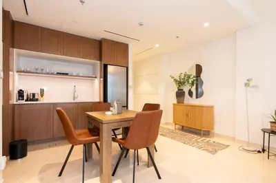 a kitchen and dining room with a wooden table and chairs at CitiHome - Private Beach Access - Emaar Beachfront in Dubai