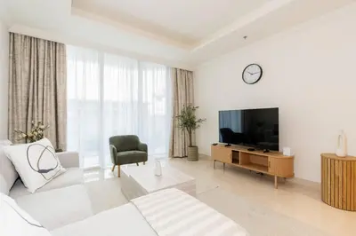 a white living room with a white couch and a television at CitiHome - Private Beach Access - Emaar Beachfront in Dubai