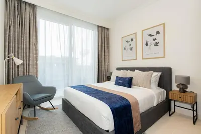 a bedroom with a bed and a chair and a window at CitiHome - Private Beach Access - Emaar Beachfront in Dubai
