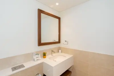 a bathroom with a white sink and a mirror at CitiHome - Private Beach Access - Emaar Beachfront in Dubai