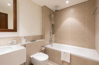 a bathroom with a tub and a toilet and a sink at CitiHome Elegant 2BR - Private Beach and Marina View in Dubai