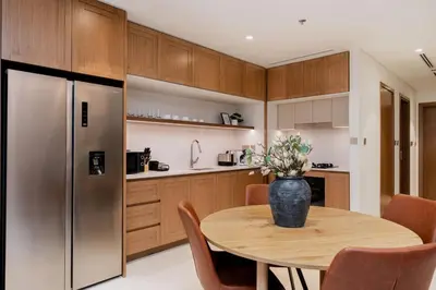 a kitchen with a table and a refrigerator at CitiHome Elegant 2BR - Private Beach and Marina View in Dubai