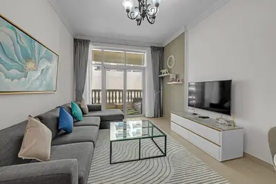 a living room with a couch and a tv at Waves - Elegant 1BR Retreat in JVC with Balcony in Dubai