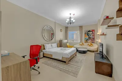a bedroom with a bed and a desk and a chair at Waves - Elegant 1BR Retreat in JVC with Balcony in Dubai