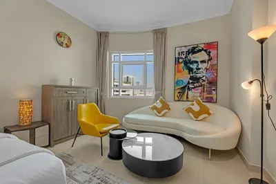 a living room with a couch and a yellow chair at Waves - Elegant 1BR Retreat in JVC with Balcony in Dubai