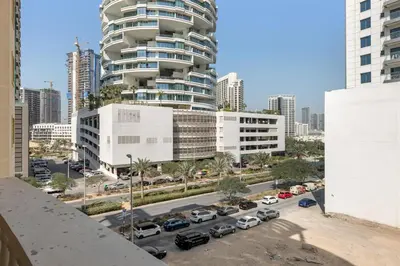 a view of a parking lot with a large building at Waves - Elegant 1BR Retreat in JVC with Balcony in Dubai