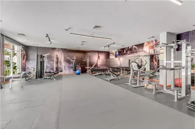 a gym with chairs and fitness equipment on the walls at Waves - Elegant 1BR Retreat in JVC with Balcony in Dubai