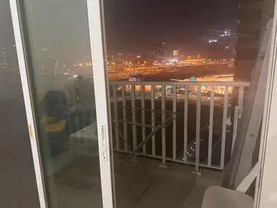 a balcony with a view of a city at night at Luxury furnished bed room for VIP family in Dubai
