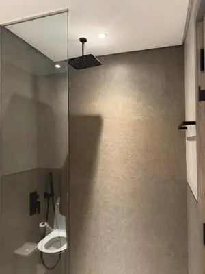 a bathroom with a toilet and a glass shower stall at Stylish Brand New 2 bed Stay near Marina in Dubai