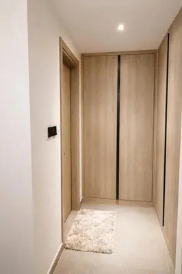 an empty room with wooden doors and a rug at Stylish Brand New 2 bed Stay near Marina in Dubai
