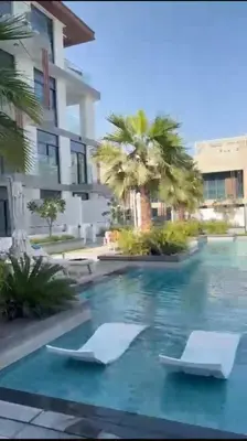 a swimming pool at a resort with palm trees at Stylish Brand New 2 bed Stay near Marina in Dubai