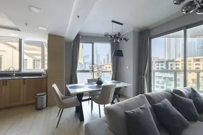 a living room with a couch and a table with chairs at Burj Khalifa & Fountain View - Downtown - 2BR in Dubai