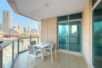 a balcony with a table and chairs on top of a building at Burj Khalifa & Fountain View - Downtown - 2BR in Dubai