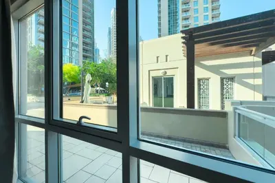 two windows in a building with a view of a statue at Burj Khalifa & Fountain View - Downtown - 2BR in Dubai