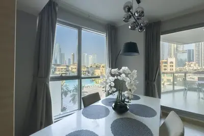 a dining room with a table and a large window at Burj Khalifa & Fountain View - Downtown - 2BR in Dubai